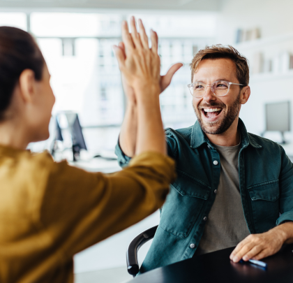 Some colleagues high-five to celebrate a success