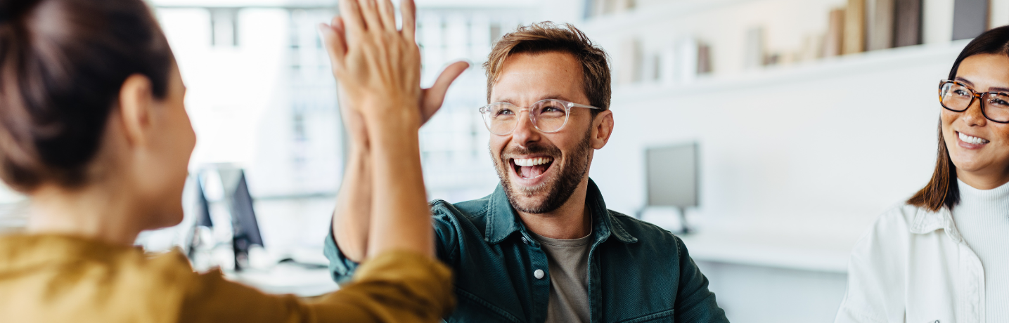 Some colleagues high-five to celebrate a success