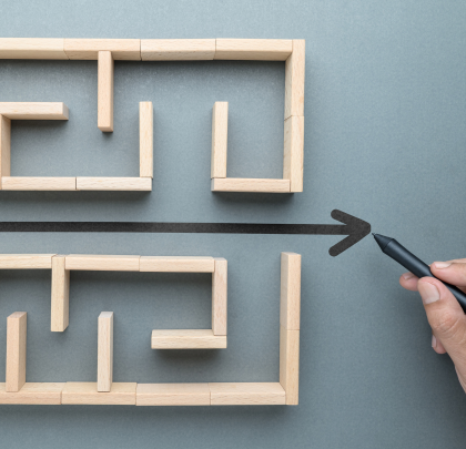 A hand drawing a straight line illustrating the way through a maze